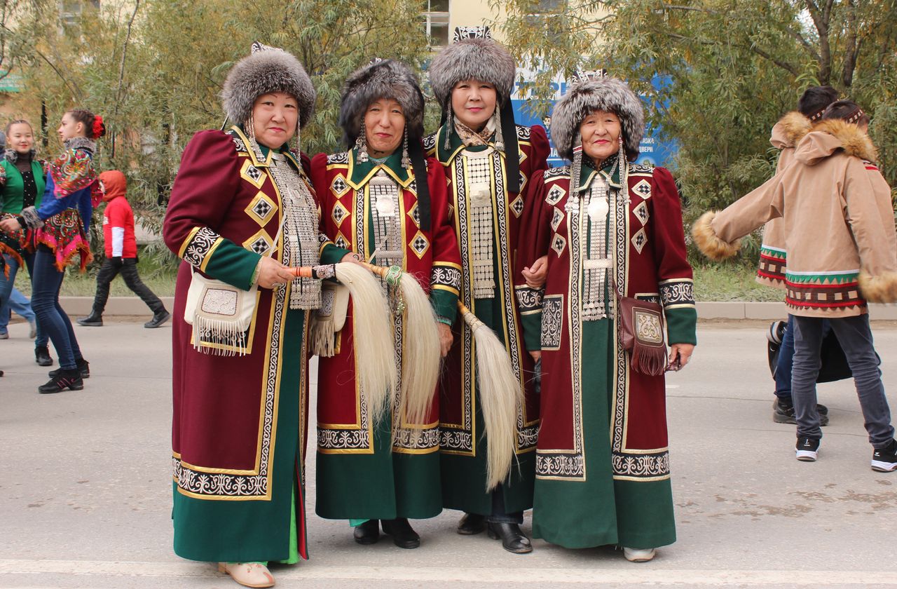 our-services-1 Group of women in traditional dress celebrating at outdoor festival.