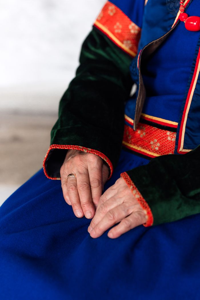 our-services-1 Detailed view of hands resting on traditional Mongolian clothing showcasing vibrant colors and embroidery.