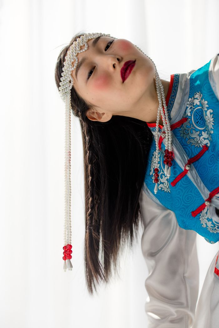 our-services-1 Artistic portrait of a woman in blue Mongolian dress with elaborate headwear and makeup.